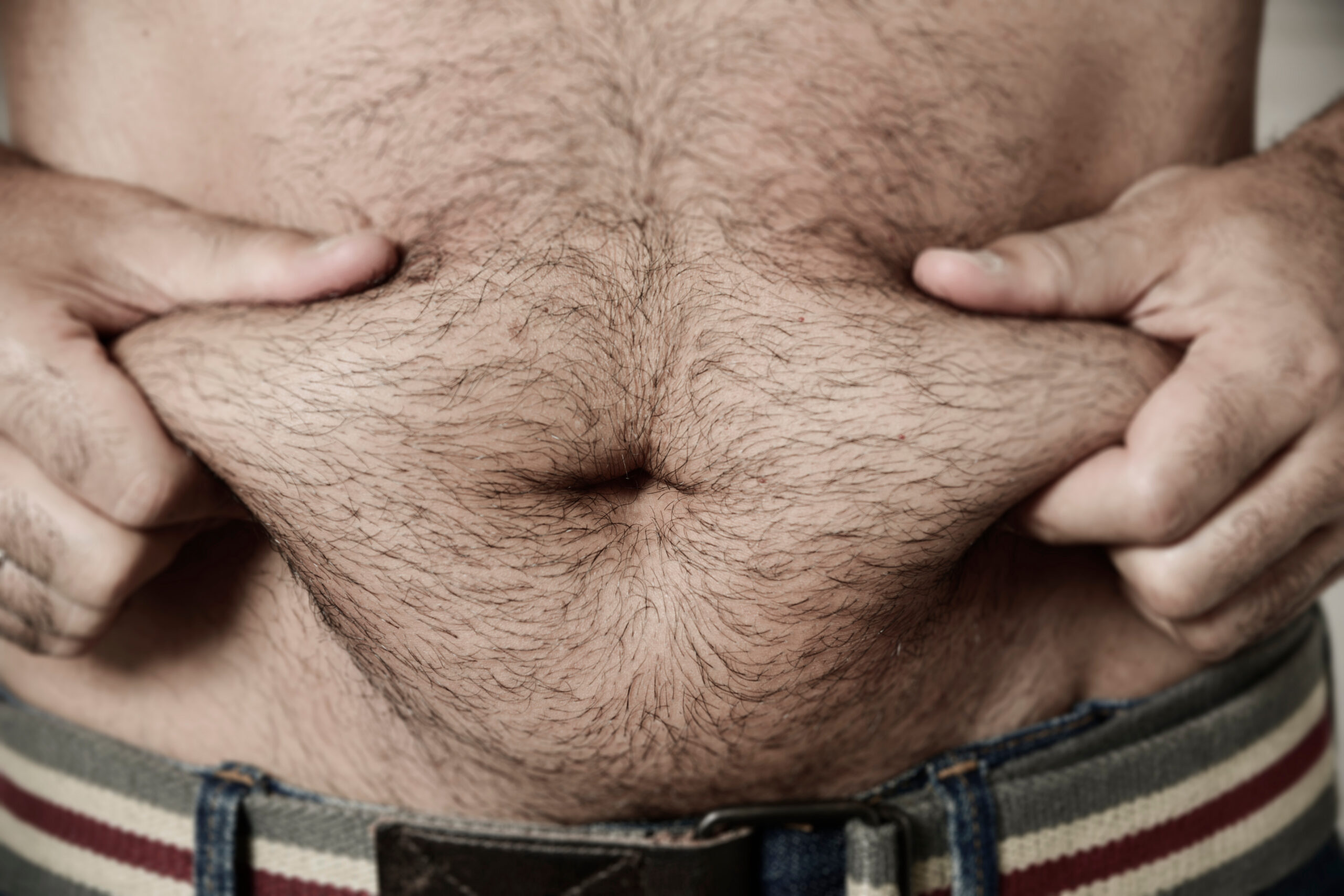 Closeup,Of,A,Young,Caucasian,Man,Grabbing,The,Fat,Of