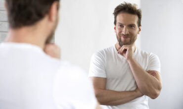 Handsome,Male,Posing,At,Mirror,,Feeling,Happy,And,Cheerful,,Satisfied